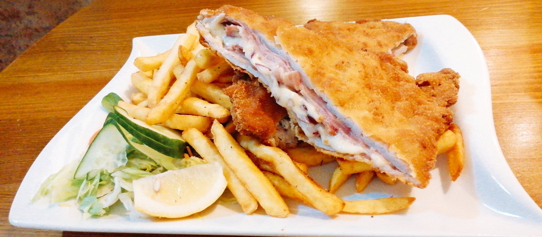 Goldgelb gebackenes Cordon Bleu mit Pommes im Gasthaus Genuss